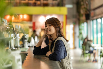 Japanese Asian woman waits at the bar counter to be served.woman patiently waiting for her order...