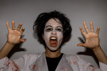 Scary zombie teenage girl with creepy expression, trick or treat in halloween