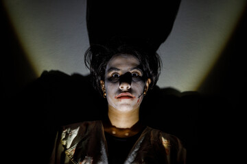 Halloween portrait of a terrifying girl with a dark shadow in the background