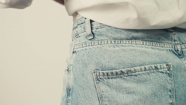 Smartphone phone with a green screen chroma key in the back pocket of jeans pants. Phone with chroma key close-up.