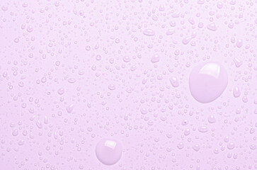 Drops of micellar water or cosmetic tonic on a pink background. Close-up, macro photography