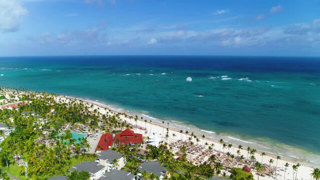 Aerial landscape of a beautiful tropical beach resort with palm trees, umbrellas and parasailing balloons. Blue ocean top view. VIK Hotel Arena Blanca, Dominican Republic, November 15, 2022
