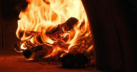 Closeup shot of fire wood burning in the oven. Traditional Italian pizzeria. Authentic Italian oven. The original pizza oven with flame inside. Slow motion burning bonfire.