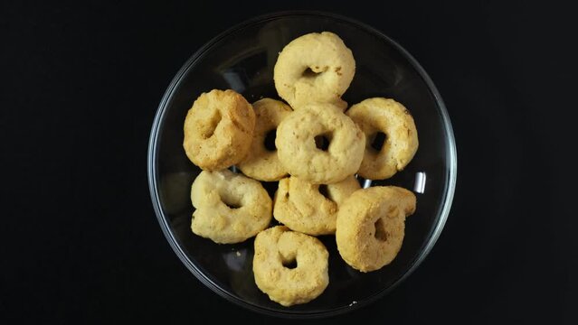 Taralli or Tarallini toroidal Italian snack foods. Crackers similar in texture to breadstick, pretzel, bublik, Sushki or baranki. Tarallini can be sweet or savory. 4K Video, Rotating. Top view.