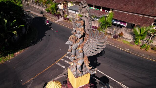 Garuda Visnu statue drone reveal at Bali, Indonesia. DJI Mavic flight around it. Not far from Besakih town. Black volcanic rock with detailed golden features craftmanship