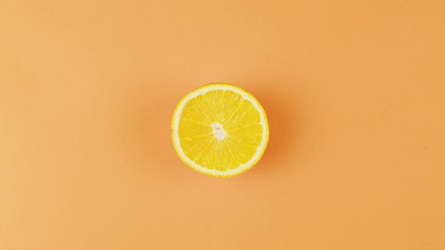 Cut lemon on the table. Fresh aroma citrus on orange background top view, close-up, zoom. Summer bright texture studio shot for shop, supermarket, restaurant, bar, travel.