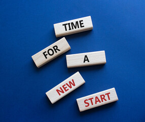 Time for a new start symbol. Wooden blocks with words Time for a new start. Beautiful deep blue background. Business and Time for a new start concept. Copy space.