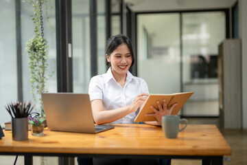 Young female employee learning job in modern office, sit in front of your laptop to start her first project.