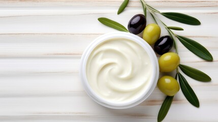 Olive face cream and olive branch on wooden background with copy space.