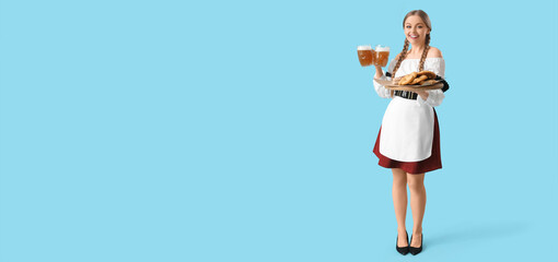 Beautiful Octoberfest waitress with beer and snacks on light blue background with space for text