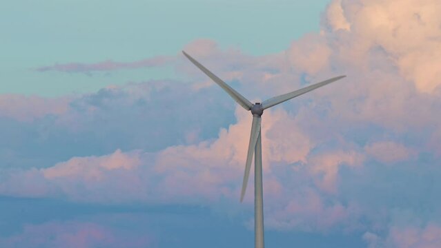 Wind turbine rotating clouds in background