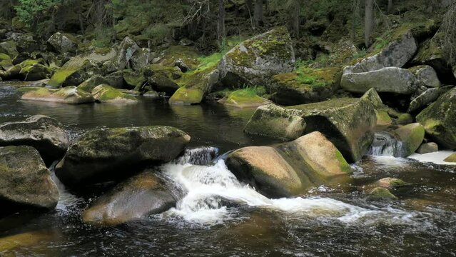 River named Otter, Vydra. The powerfull stream of the river in the Sumava Park pushes huge boulders down into the valley.