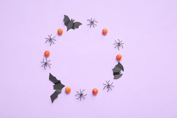 Frame made of pumpkins, paper bats and spiders on purple background. Halloween celebration concept