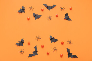 Composition with pumpkins, paper bats and spiders on orange background. Halloween celebration concept