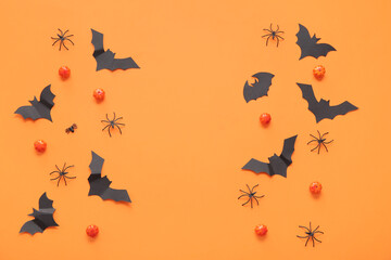 Composition with pumpkins, paper bats and spiders on orange background. Halloween celebration concept