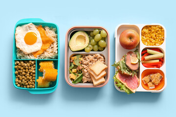 Many lunchboxes with different delicious food on blue background