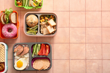 Lunchboxes with different delicious food on pink tile background