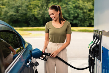 Smiling Woman Refilling Auto with Fuel at Modern Petrol Station