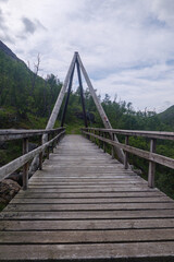 Obraz premium Brücke über Fluss Skåkbekken im Dovrefjell Nationalpark in Norwegen bei Kongsfold, ein Nebenfluss der Driva. Gesehen auf dem Pilgerweg St. Olavsweg, Gamle Kongevegen auf dem Weg Oslo nach Trondheim