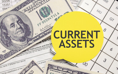 CURRENT ASSETS words on yellow sticker with dollars and charts