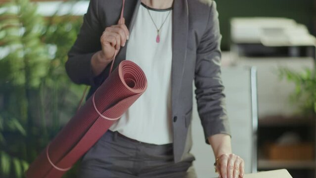 Sustainable workplace. smiling modern small business owner woman at work with wireless headphones, laptop and yoga mat.