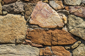 Fragment of a natural stone wall as a background or texture. The structure of the stone wall. Old castle stone wall texture background. Мasonry background