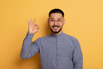 Happy Young Asian Man Showing Ok Gesture At Camera