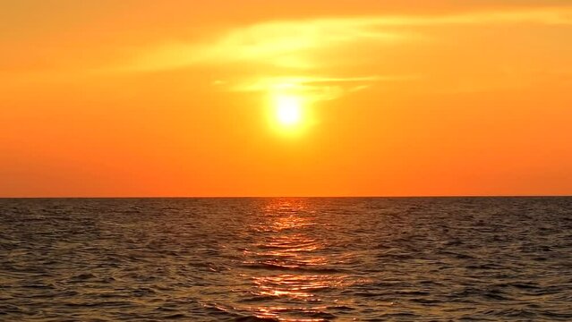 Beautiful sea waves with shiny reflection of yellow and gold sunset light. Colorful clouds on the orange sky, calm horizon scene view, sunny day, sun, outdoor, mid shot, slow motion, hd. ProRes 422 HQ
