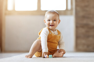 Adorable blonde infant baby playing with kids toys at home - obrazy, fototapety, plakaty