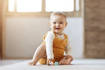 Fototapeten Adorable blonde infant baby playing with kids toys at home © Prostock-studio
