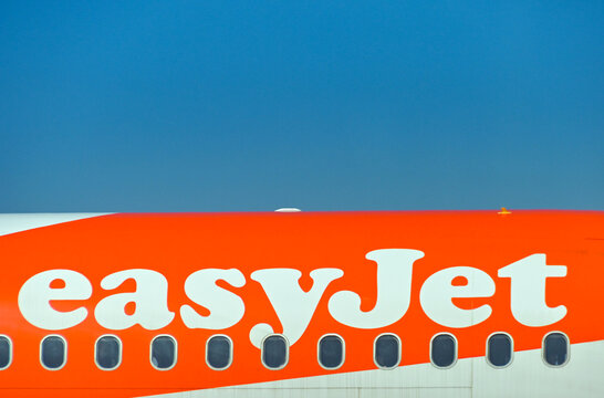 Luqa, Malta - 9 August 2023: Close up view of the logo on the side of a, easyJet holiday plane at Malta International Airport