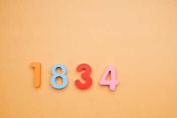  1834 toy block on orange background , - obrazy, fototapety, plakaty