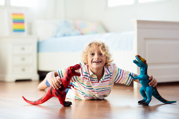 Child playing with toy dinosaurs. Kids toys.