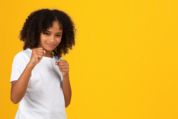 Smiling confident strong adolescent african american girl in white t-shirt, show fists, fight,...