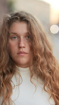An up-close view of the girl's face reveals her freckles and cascading curls.