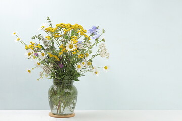 Flower arrangement of wild herbs and flowers , autumn background, tansy, mint, celandine, chamomile and yarrow in a jar , collection of useful herbs for treatment according to folk recipes.