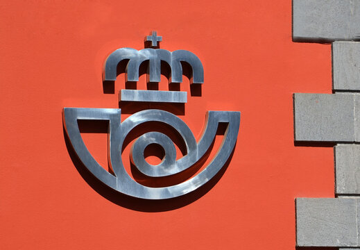 Tenerife,Canary Islands,Spain - August 6, 2023: Logo sign of the national Spanish postal service Correos on the wall a post office in La Laguna.
