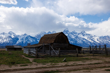 The John Moulton barn with the snow covered Teton Mountains in the background in Jackson Hole, Grand Teton National Park during spring
