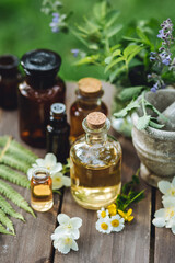 Assortment of pure organic natural essential aroma oil with mint , camomile on wooden background. Concept of herbal, floral ingredients in cosmetology. Alternative medicine, therapy, Ayurveda