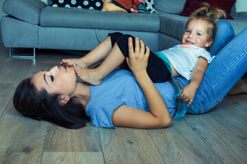 Hands, feet flying; mom, daughter's loving play