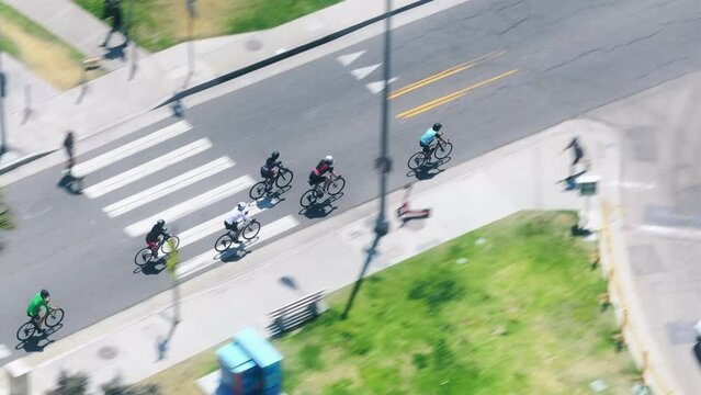 Drone shot of male cyclists riding on bicycles on road of Santa Monica, Los Angeles, California, USA. Aerial view of men training on bikes outdoors. Athletes having outdoor workout, 4k footage