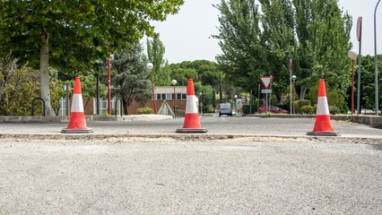 Traffic cones in front of a ditch to signal asphalt conditioning works