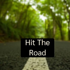 Composite of hit the road text over road and forest landscape