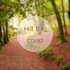 Composite of hit the road text over path and forest landscape