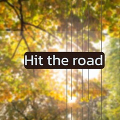 Composite of hit the road text over trees in forest