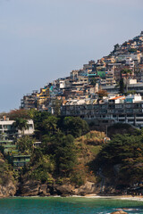 Fototapeta na wymiar Vidigal beach and Morro do Vidigal in Rio de Janeiro, Brazil. Pacified community or favela. Slum. Sunny day with blue sky and some clouds. Turquoise and clear sea