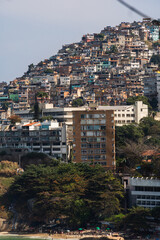 Naklejka premium Vidigal beach and Morro do Vidigal in Rio de Janeiro, Brazil. Pacified community or favela. Slum. Sunny day with blue sky and some clouds. Turquoise and clear sea