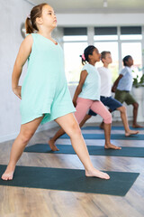 Fototapeta premium Young kids, doing horse rider exercise, anjaneyasana pose, working out.