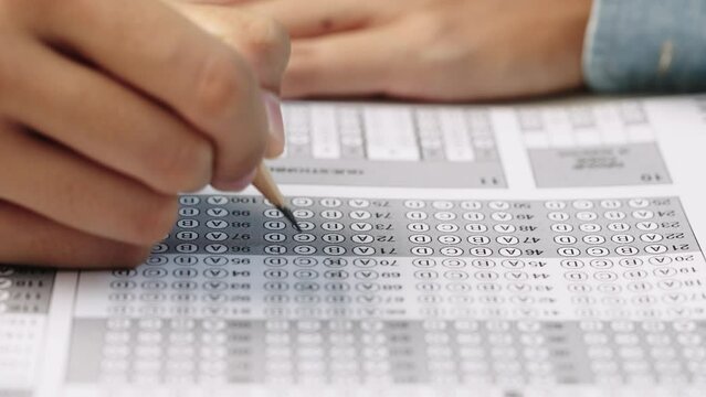 Student take exam choice with hands and write the exam test answer sheet with pencil,Answering test questions on the exam concept