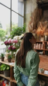 The customer, a young woman, is scrutinizing the items available at the flower store.